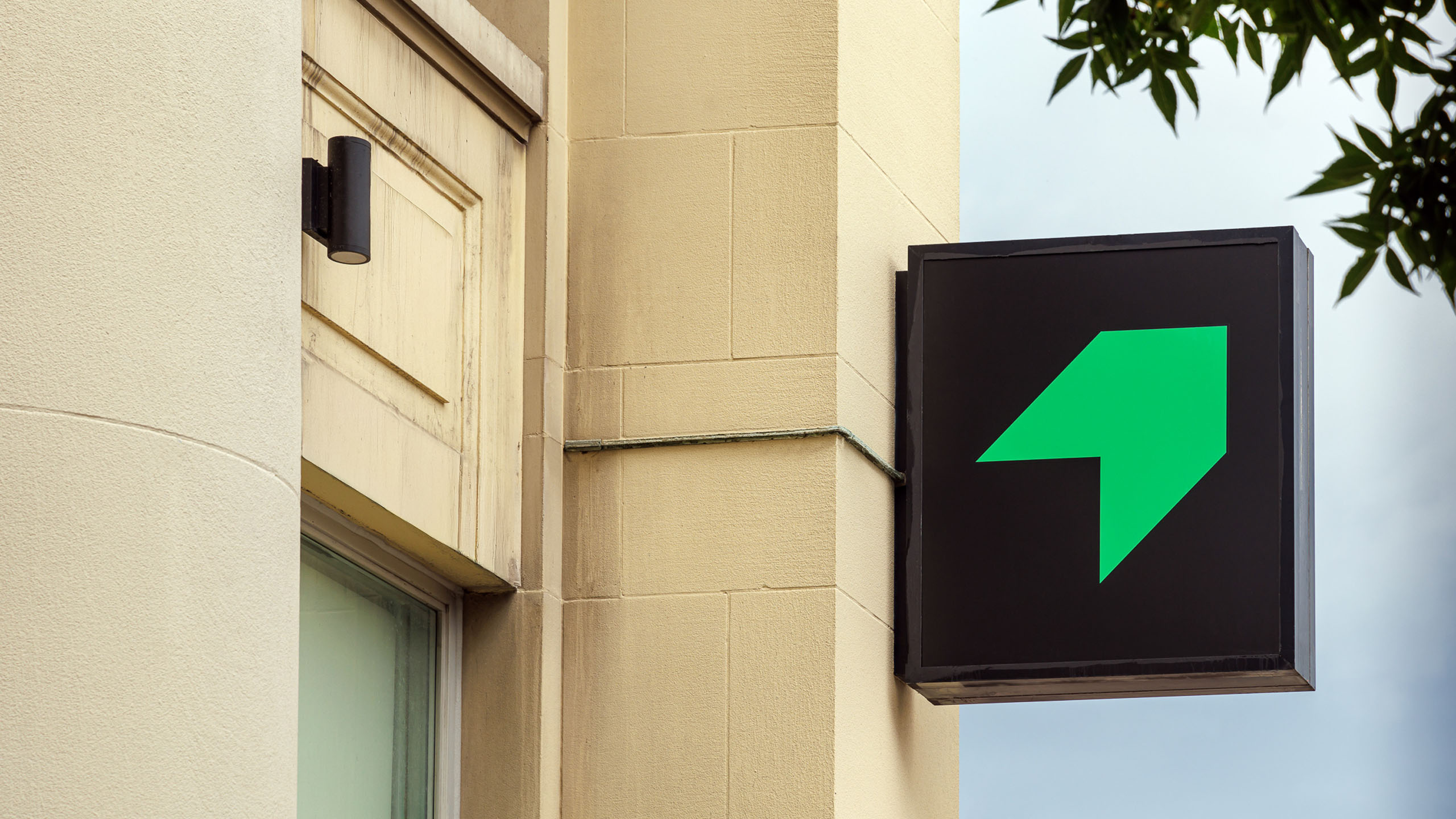 Signage from Raw Signal Group's building exterior, featuring their green chevron symbol.